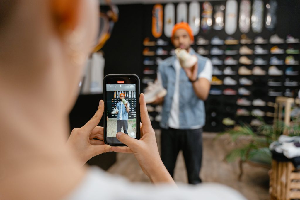 a man holding rubber shoes having his photo taken